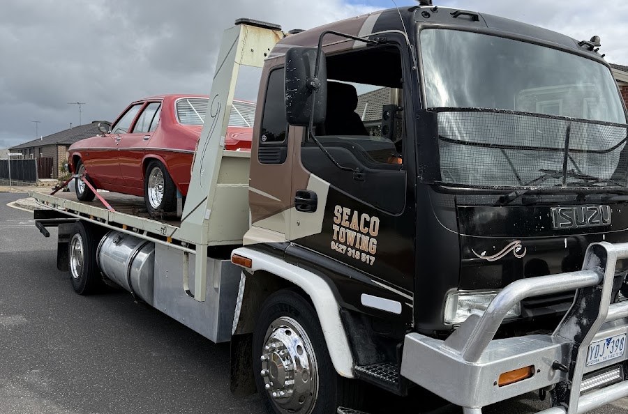 Seaco Towing tilt tray truck in Geelong loaded with a red classic Holden